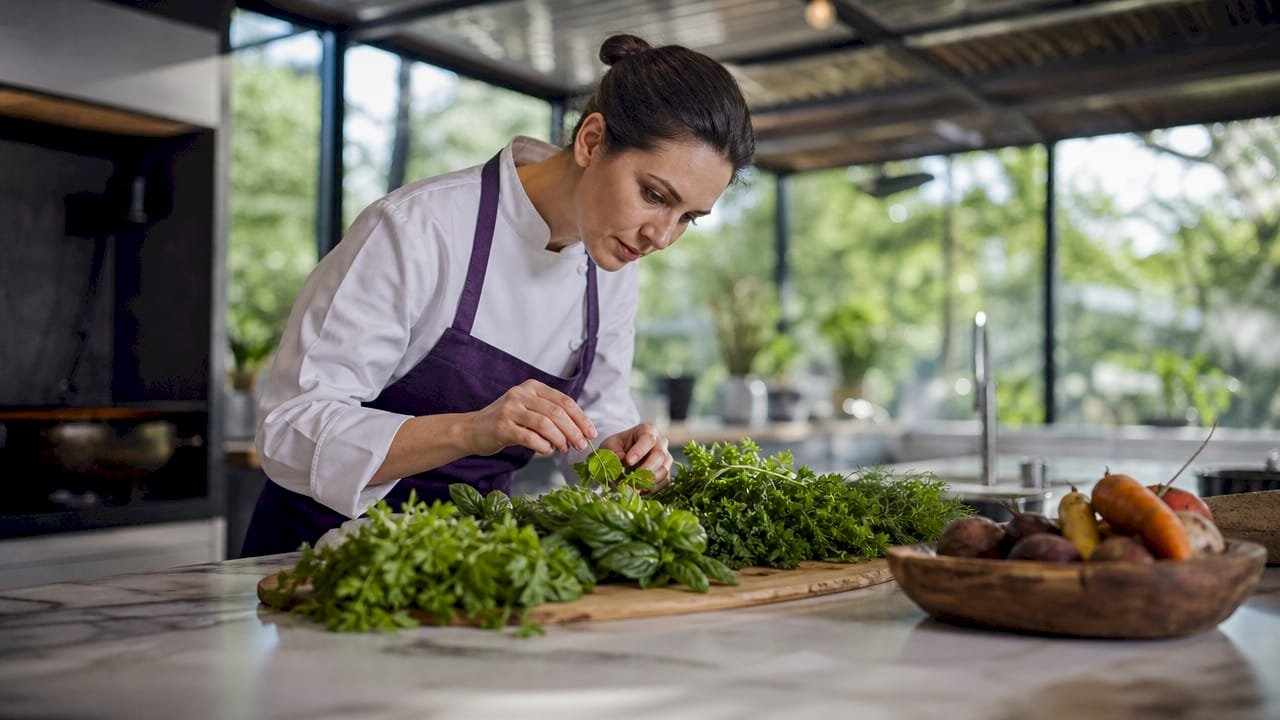 Chef examining fresh vegetables in commercial kitchen