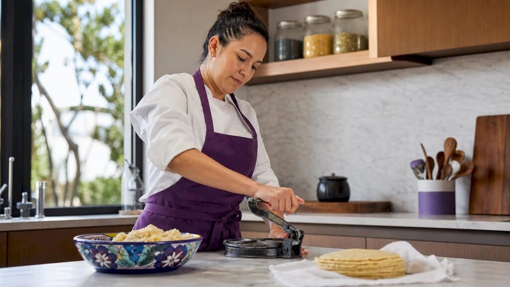 Chef pressing fresh corn tortillas in kitchen