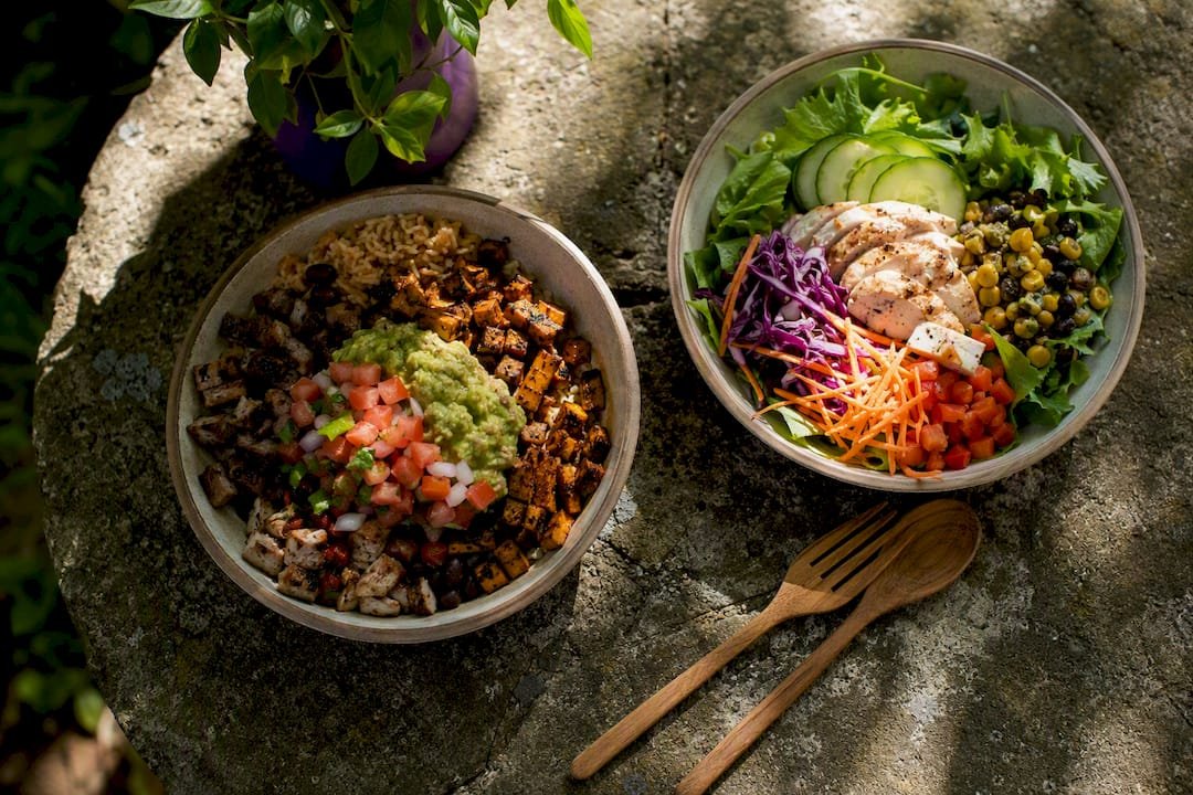 Two contrasting naked burrito bowls showing toppings and prices