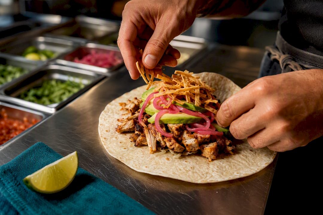 Hands assembling a rice-free burrito